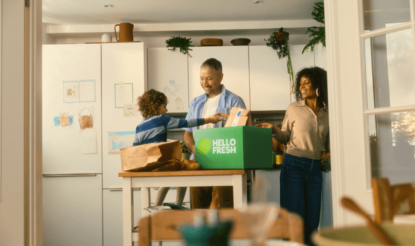 Family unpacking a HelloFresh delivery box in their bright modern kitchen, showcasing easy meal solutions with healthy food savings for disabled people, inclusive family meal discounts, and accessible cooking offers.