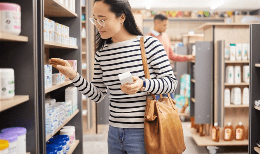 Young woman browsing medicine aisle at Pharmacy2U – NHS repeat prescriptions and personal healthcare discounts for disabled people in the UK.