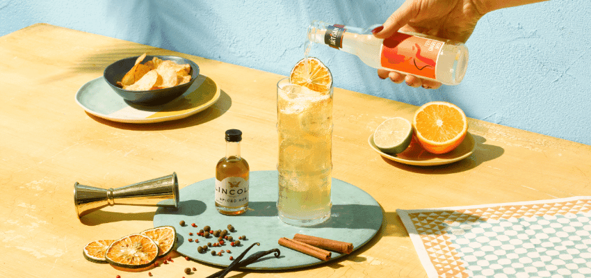 Hand pouring bottled mixer into iced cocktail, Lincoln, Purpl discounts for disabilities and long term health conditions, mobility discounts and offers.