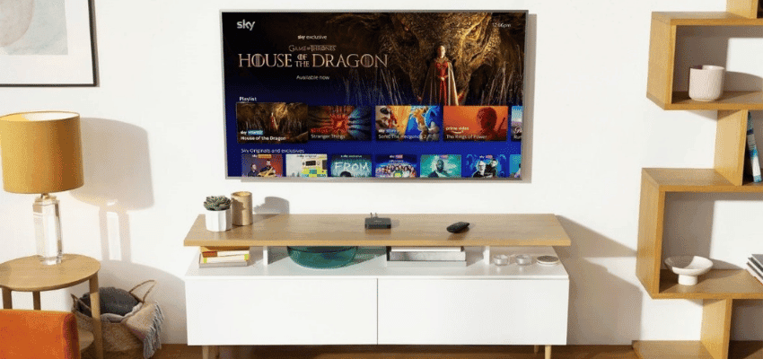 A flat tv is on the wall, the screen shows Sky TV menu with House of Dragons featured at the top. Below the TV is a white cabinet with an oak top.