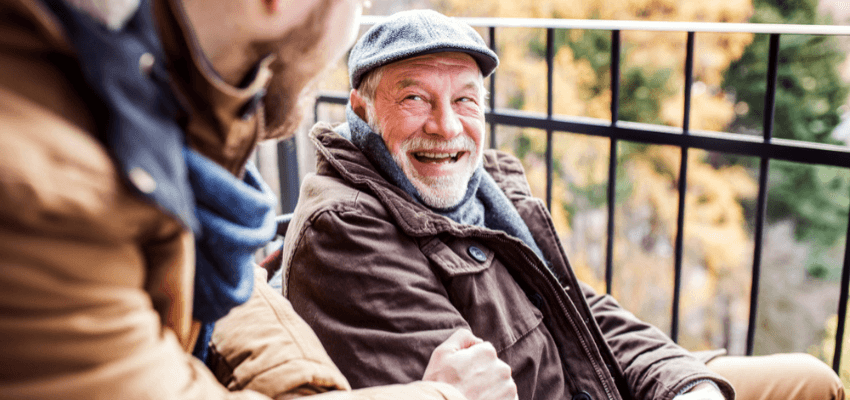 Elderly man smiling with carer outdoors in autumn, County Cousins Disabled Discounts UK and Carer Savings Offers.