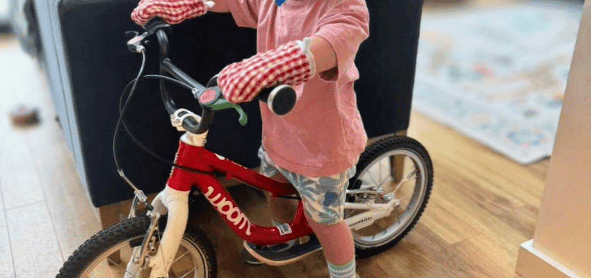 Child riding red balance bike indoors Purpl disabled discounts members save on kids bikes and mobility friendly products