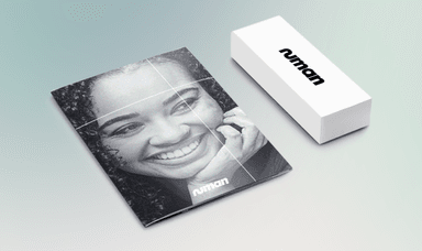 Smiling woman on glossy Numan booklet with matching white Numan box on pastel background. Health and wellness starter kits. Medical support for men and women. Online health consultations. Mobility discounts and offers.