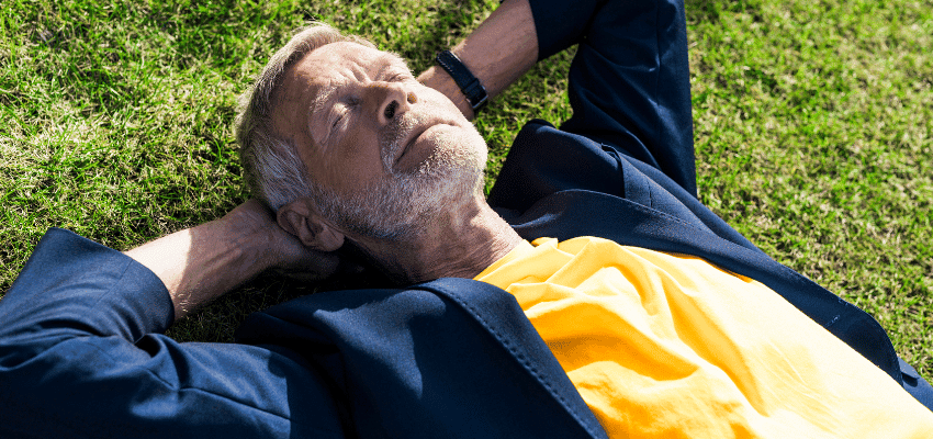 Man relaxing on grass in sunlight, Holland & Barrett Purpl discounts for disabilities and long term health conditions, mobility discounts and offers.