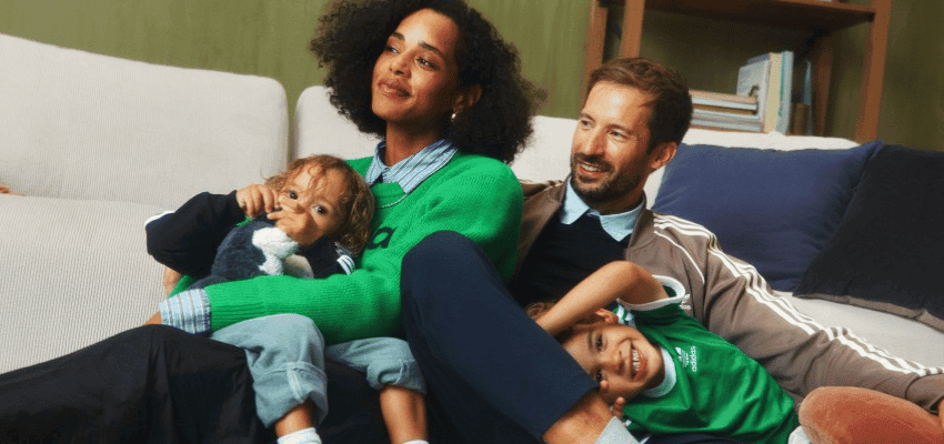Family relaxing together on a sofa wearing adidas clothing Purpl discounts shopping discounts for disabled people accessibility discounts UK mobility discounts and offers savings for people with long term health conditions cost of living help for disabled people