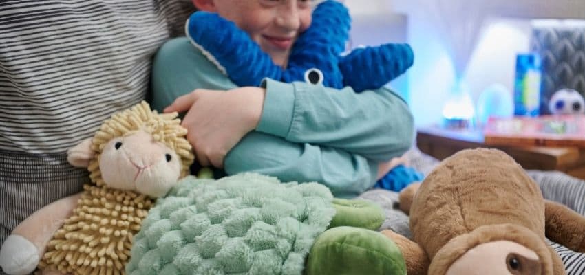 Child cuddling colourful soft toys, Purpl discounts for disabilities and long term health conditions, mobility discounts and offers.
