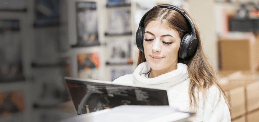 Woman wearing headphones browsing vinyl at RareVinyl, Purpl discounts for disabilities and long term health conditions, shopping discounts for disabled people.