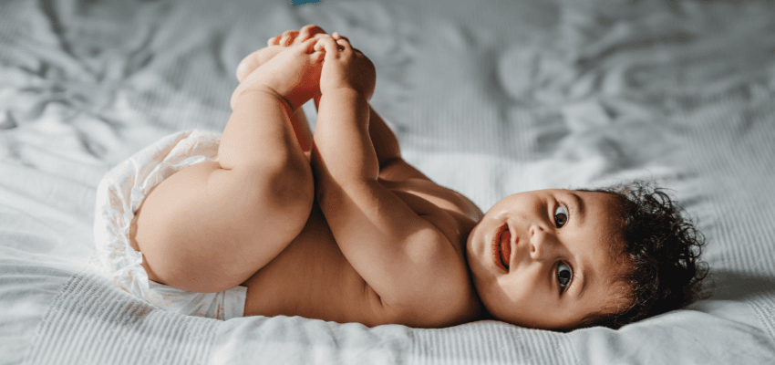 Smiling baby lying on a bed, Purpl discounts for disabilities and long term health conditions, shopping discounts for disabled people.