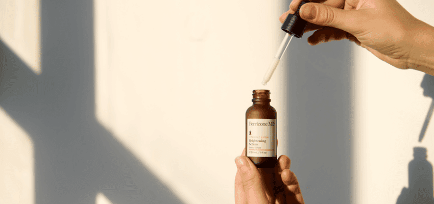 Hand holding Perricone MD serum dropper bottle, Purpl discounts for disabilities and long term health conditions, shopping discounts for disabled people.