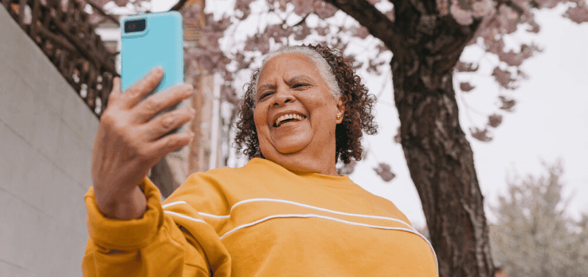 Smiling woman taking a selfie outdoors with EE, Purpl discounts for disabilities and long term health conditions, shopping discounts for disabled people.