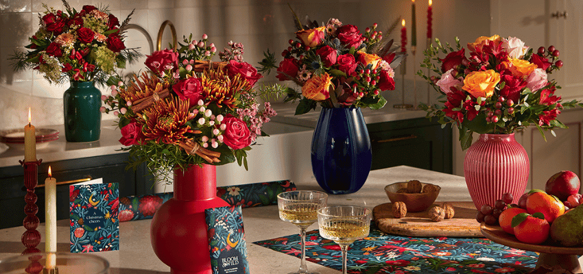 Festive Bloom & Wild Christmas flower bouquets displayed in colourful vases on a kitchen counter, showcasing vibrant gifting options with Bloom & Wild disability discount savings, perfect for accessible Christmas gift ideas and seasonal offers for disabled people.