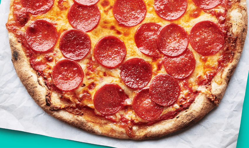 Pepperoni pizza with a golden crust on parchment paper