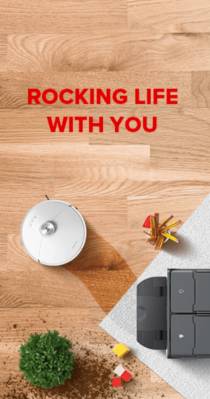 Top-down view of a Roborock robot vacuum gliding across a wooden floor with scattered soil, kids' toys, and pencils, demonstrating automatic cleaning power. Ideal for mobility discounts and offers that help disabled people simplify everyday tasks at home.