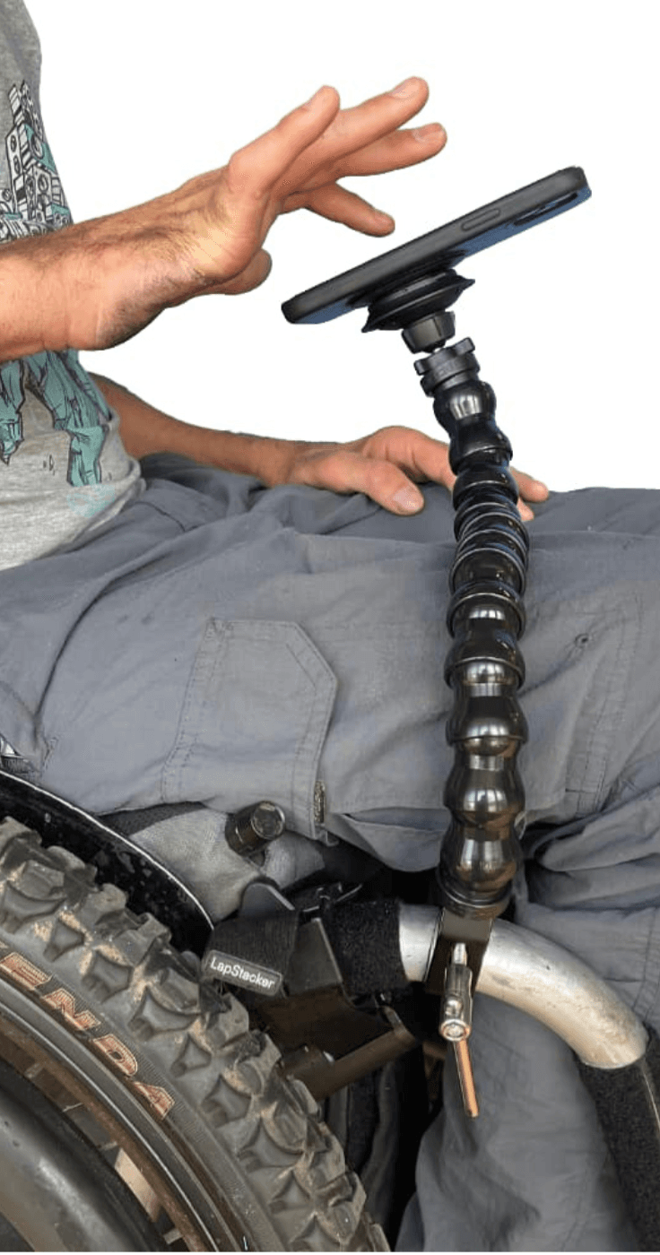Close-up of a disabled person using a flexible wheelchair-mounted phone holder to access their device independently, showcasing accessible tech for daily life and mobility discounts and offers.