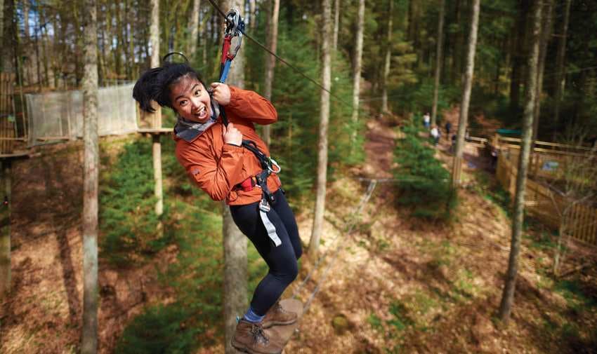 Woman ziplining through forest at Go Ape, Purpl discounts for disabilities and long term health conditions, disabled travel discounts UK.