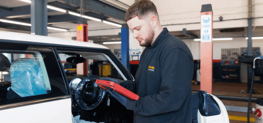 Halfords mechanic using diagnostic tool on car Purpl disabled discounts members save on vehicle checks and car repair services