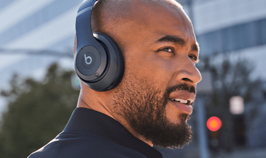 A man with headphones on his head, looking off into the distance
