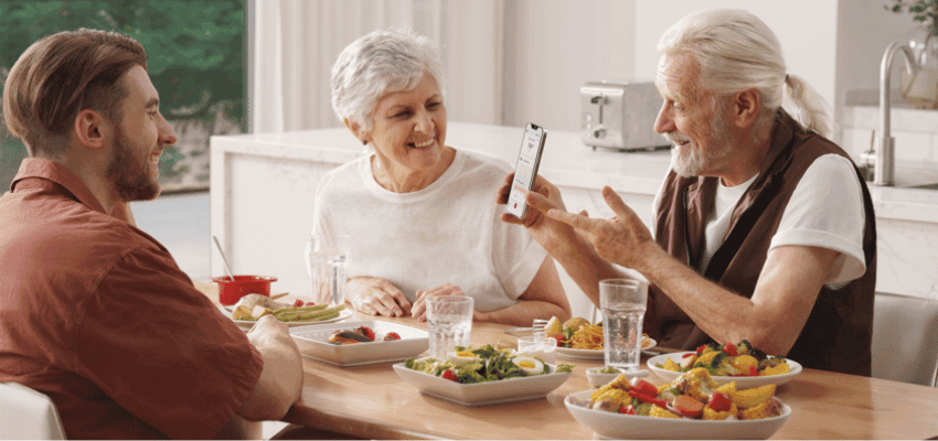 Family at the table reviewing Sinocare diabetes results on a phone, healthy living support.