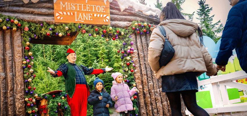 Alton Towers Christmas event with families meeting an elf at Mistletoe Lane, festive lights and decorations, featuring UK disabled visitor discounts and accessible days out offers.