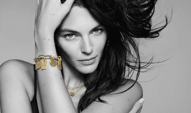 A confident woman wears layered Pandora gold jewellery including charm bracelets and necklaces ideal for those browsing for fashion accessories with mobility discounts and offers in the UK.