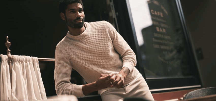 Man in casual knitwear leaning outside café representing Jacamo men’s fashion deals, part of exclusive mobility discounts and disabled shopping offers.