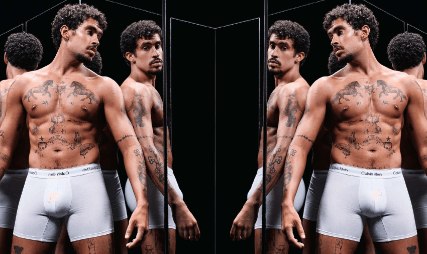 Calvin Klein men’s underwear campaign with male model in white boxers, modern fashion branding, inclusive shopping discounts for disabled people and long term health conditions.