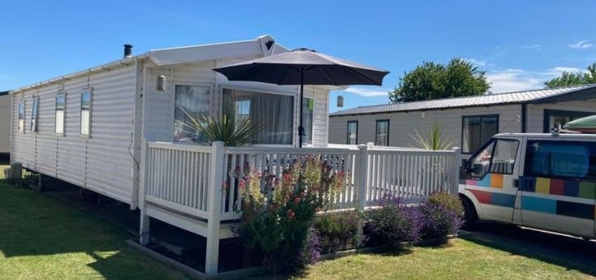 White holiday caravan with veranda and flowers, Holistic Thinking Holidays: Purpl discounts for disabilities and long term health conditions, mobility discounts and offers.