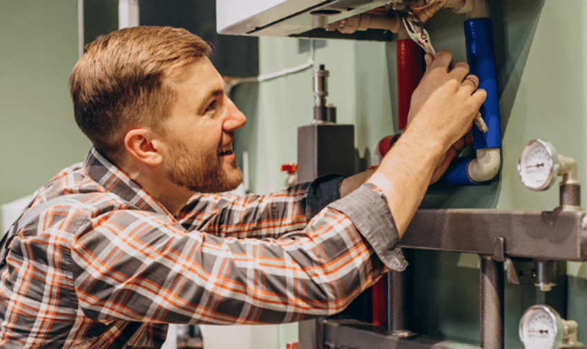 Friendly gas engineer servicing a domestic boiler system in a home. Inclusive boiler insurance for disabled people UK with nationwide emergency heating repairs and disabled household protection plans.