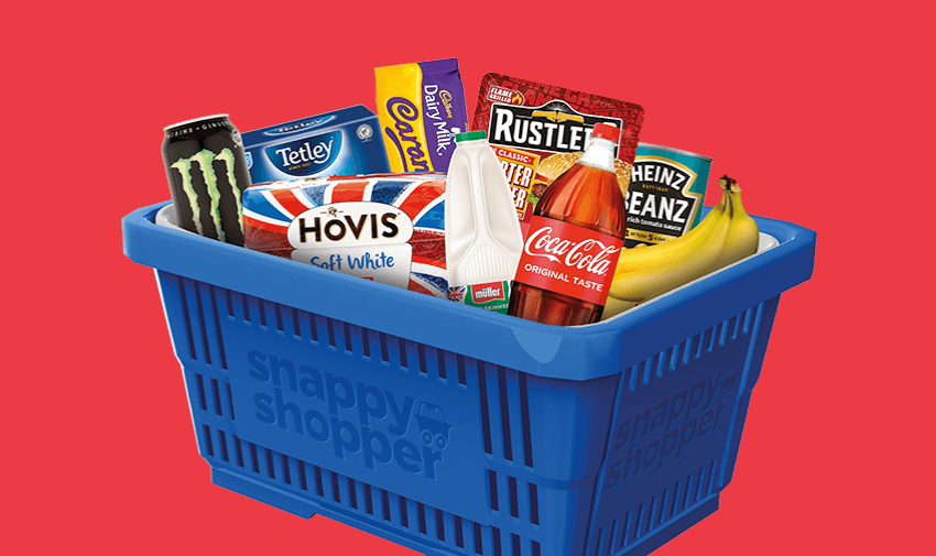 Blue Snappy Shopper basket filled with popular grocery items including Monster energy drink, Tetley tea, Cadbury Dairy Milk, Hovis bread, Müller milk, Rustlers burger, Coca-Cola, Heinz baked beans, and bananas, promoting local delivery discounts for disabled people.
