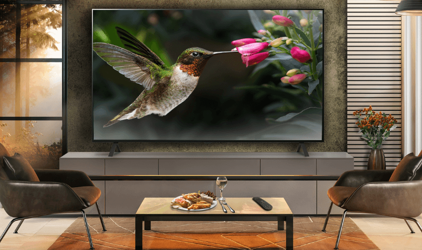Wall-mounted smart TV glowing with ambient light in a cosy living room. Perfect for accessible home entertainment tech and disabled-friendly smart home discounts UK.