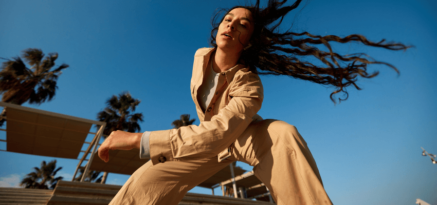 Woman dancing outdoors under palm trees, O2 Purpl discounts for disabilities and long term health conditions, mobility discounts and offers.