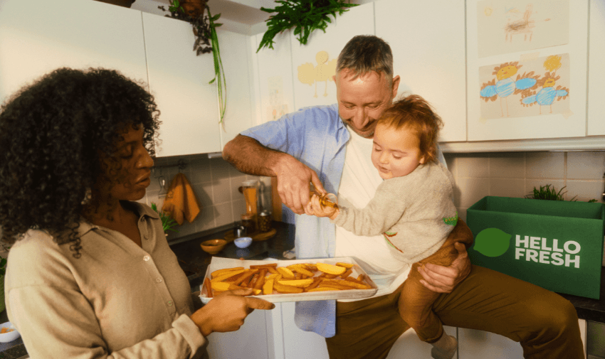 Family unpacking a HelloFresh delivery box in their bright modern kitchen, showcasing easy meal solutions with healthy food savings for disabled people, inclusive family meal discounts, and accessible cooking offers.
