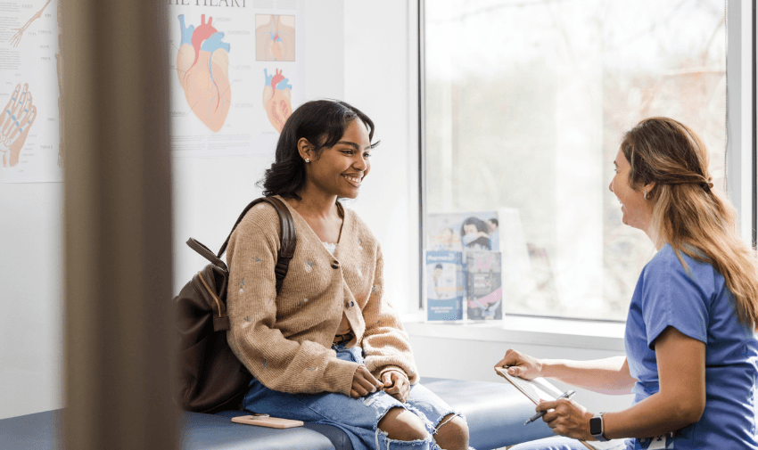 Disabled woman smiling in a GP consultation – accessible health support and online pharmacy services for people with long-term health conditions.