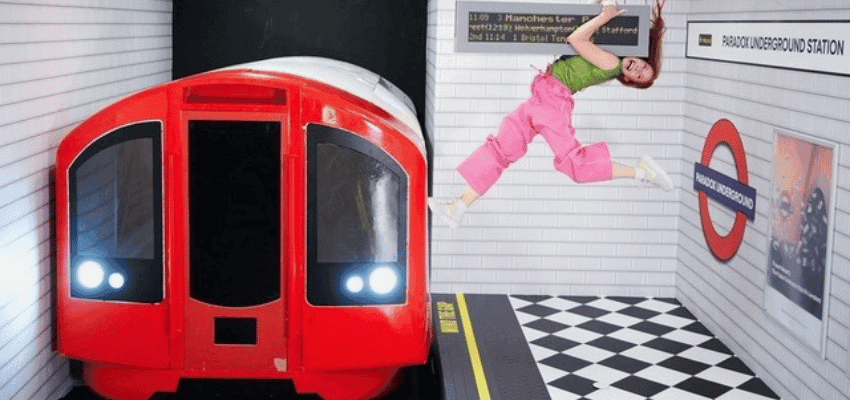 Woman posing mid-air in a playful illusion at the Paradox Museum London, featuring a mock underground train scene. Promotes Tiqets’ discounted entry offers through Purpl Disabled Discounts, highlighting fun, accessible days out and sensory-friendly attractions in the UK.