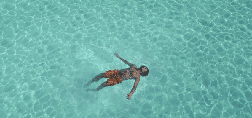 A person relaxing and floating in crystal-clear turquoise water, ideal for EasyJet Holidays' sunny and relaxing getaway offers.