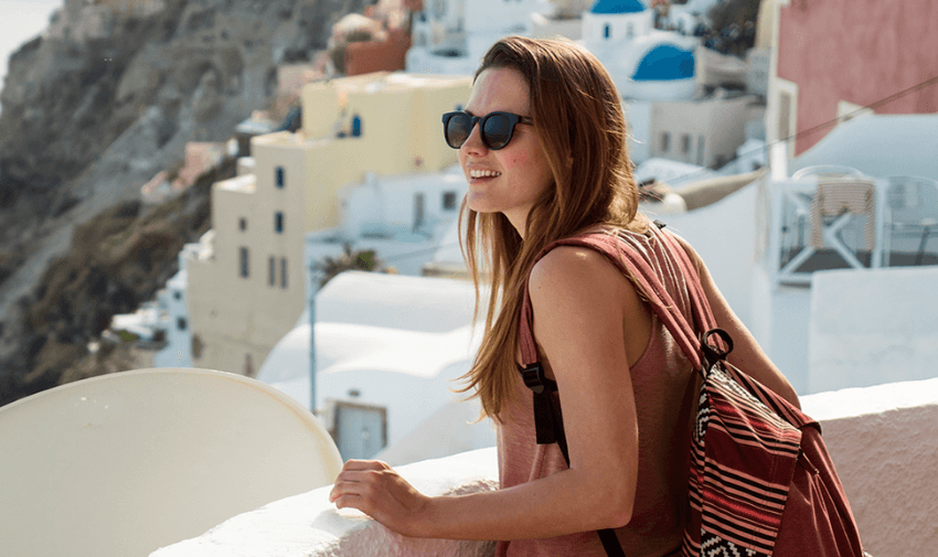 Woman smiling while a driver helps with luggage in a European city. Promotes accessible travel services, inclusive car transfers and disabled-friendly holiday experiences.
