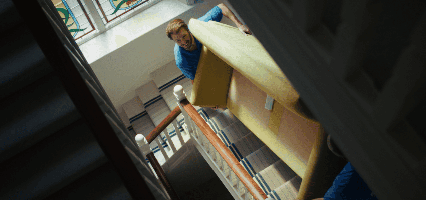 Removal worker carrying a sofa up stairs, AnyVan Purpl discounts for disabilities and long term health conditions, mobility discounts and offers.