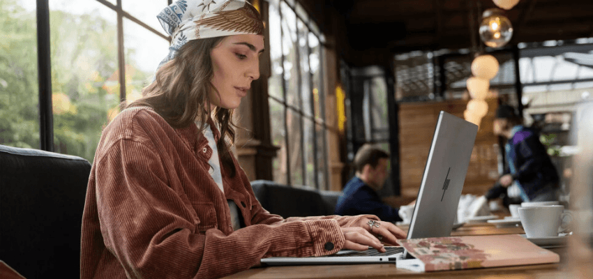 Woman working on HP laptop in café, Purpl discounts for disabilities and long term health conditions, mobility discounts and offers.