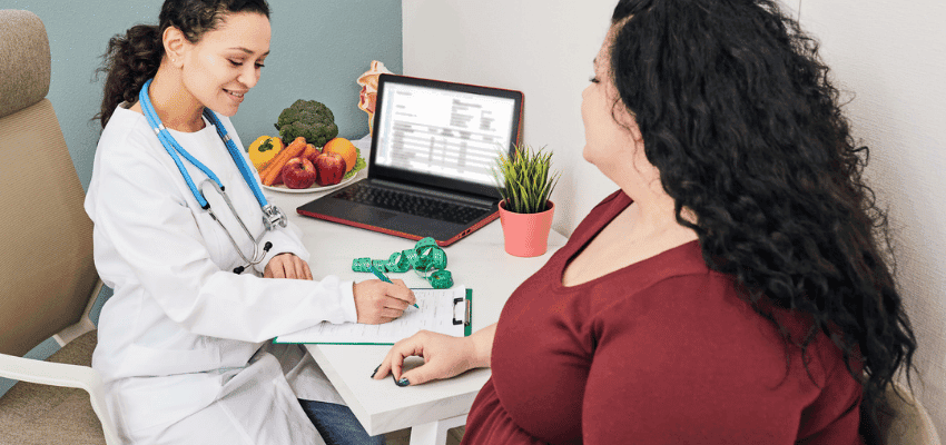 Doctor consulting patient at desk, Lloyds Pharmacy Purpl discounts for disabilities and long term health conditions, shopping discounts for disabled people.