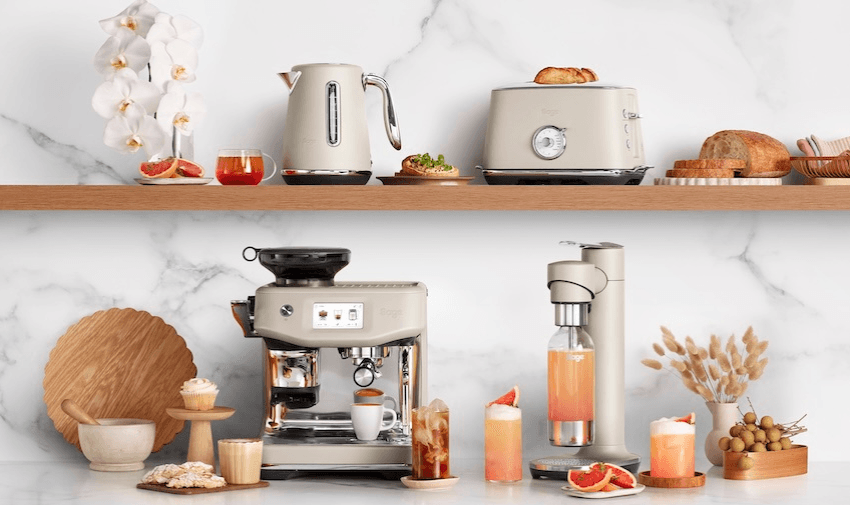 Beige Sage coffee machine, kettle, toaster and sparkling drink maker on a modern shelf with pastries and summer drinks. Inclusive kitchen discounts – accessible home appliances for disabled adults and carers in the UK.