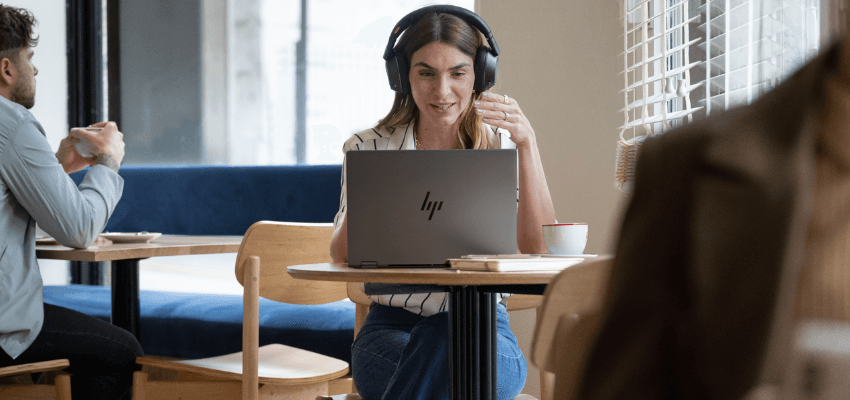 Woman using laptop in café, Currys Purpl discounts for disabilities and long term health conditions, shopping discounts for disabled people.