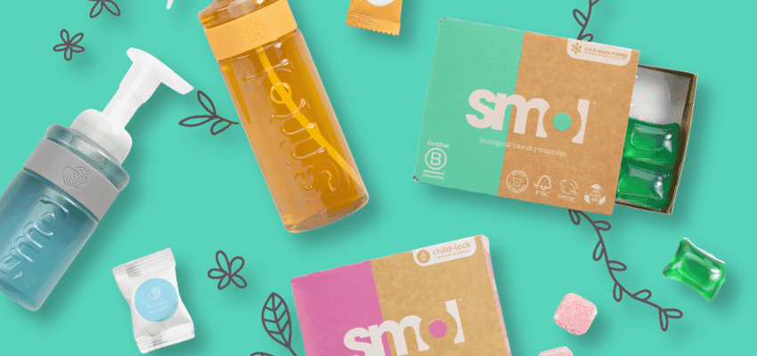 Flat lay of eco-friendly Smol cleaning products on a turquoise background, including refill bottles, laundry capsules, and dishwasher tablets. Sustainable cleaning essentials with biodegradable ingredients and refillable packaging for Purpl members’ home savings and eco discounts.