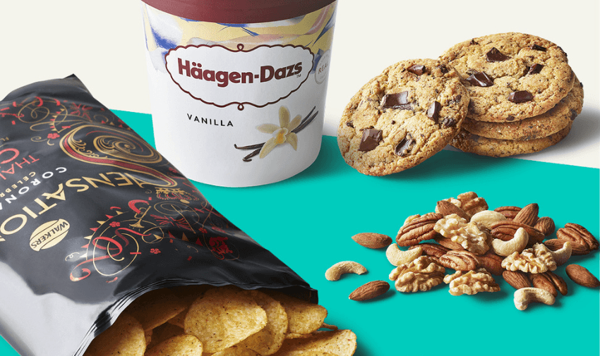 Assortment of snacks including crisps, vanilla ice cream, cookies, and mixed nuts.