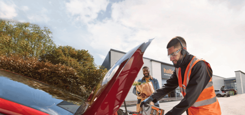 Halfords mechanic helping customer with car fluids Purpl disabled discounts members save on motoring services and vehicle care