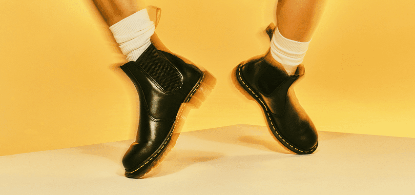 Feet wearing black Dr. Martens boots, Purpl discounts for disabilities and long term health conditions, mobility discounts and offers.