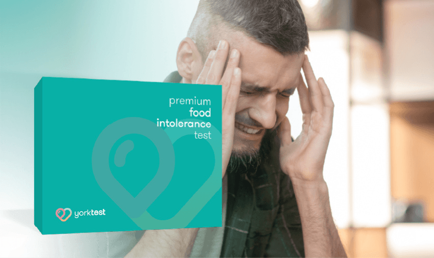 Man with headache holding YorkTest kit – premium food intolerance test UK for gut and migraine relief.