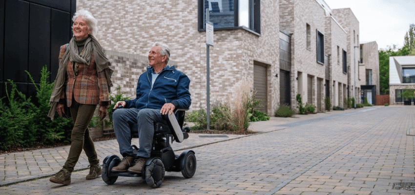 Smiling couple with mobility scooter outdoors, Millercare Purpl discounts for disabilities and long term health conditions, mobility discounts and offers.