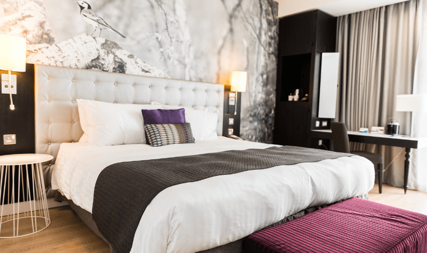 Modern hotel room with wide access, a plush bed and spacious layout. Holiday discounts for disabled travellers.