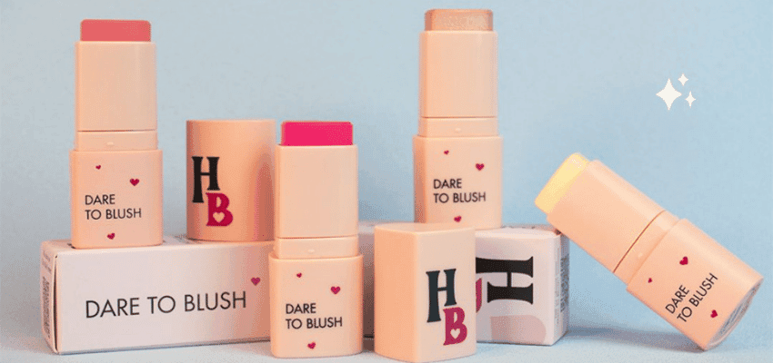 Human Beauty makeup products displayed in pastel packaging, showcasing inclusive beauty essentials with accessibility in mind and Purpl discounts for disabled people and long term health conditions.