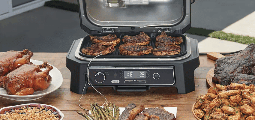 Ninja food grill cooking steaks with side dishes – mobility-friendly kitchen gadgets with disabled savings UK.